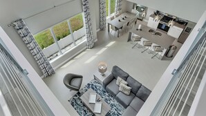 A modern apartment with a dining area, kitchen, and living space.