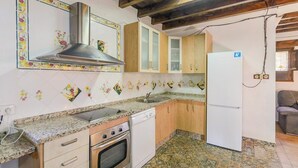 A kitchen with a stove, oven, sink, and cabinets. - Combinación Serval y Pedrizas Montefrío by Ruralidays (Granada)