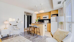 Una cocina moderna con una isla central, armarios blancos y un microondas.