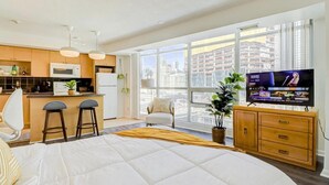 Un apartamento moderno con cocina, comedor y una cama grande.