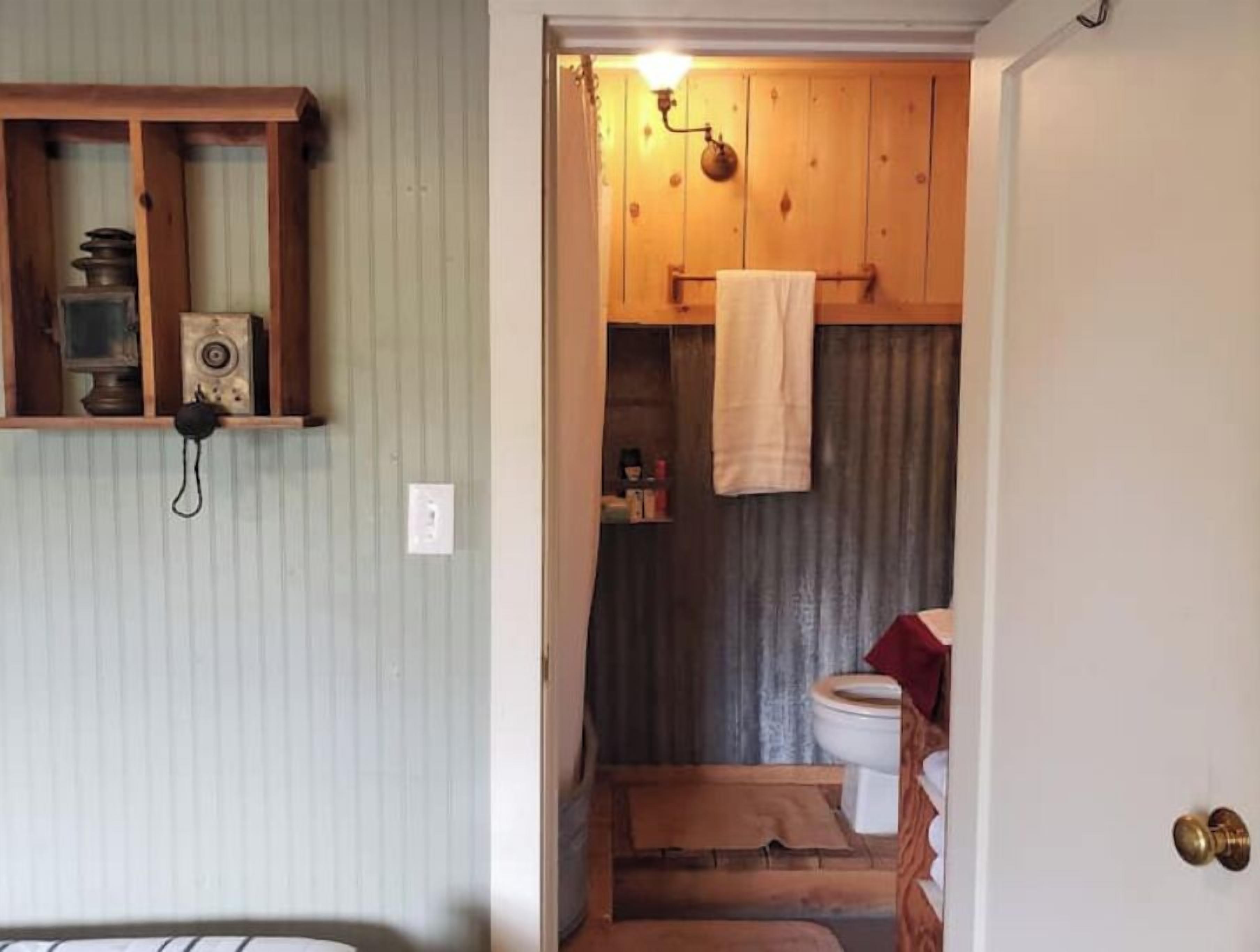 Une petite salle de bain avec un meuble-lavabo en bois, des toilettes et un espace douche.