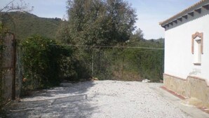 A gravel driveway leading to a white building with a red-tiled roof. - Cortijo el Maurel Cajiz by Ruralidays (Málaga)