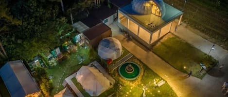 Vista aérea de una propiedad con un edificio de gran cúpula, varias tiendas de campaña y un jardín circular.