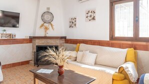 A living room with a fireplace, a sofa, and a coffee table. - La Antigua Fábrica Teba by Ruralidays (Málaga)