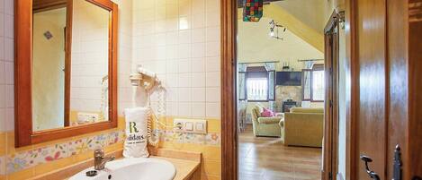 Ein Badezimmer mit Waschbecken, Spiegel und Handtuchhalter.