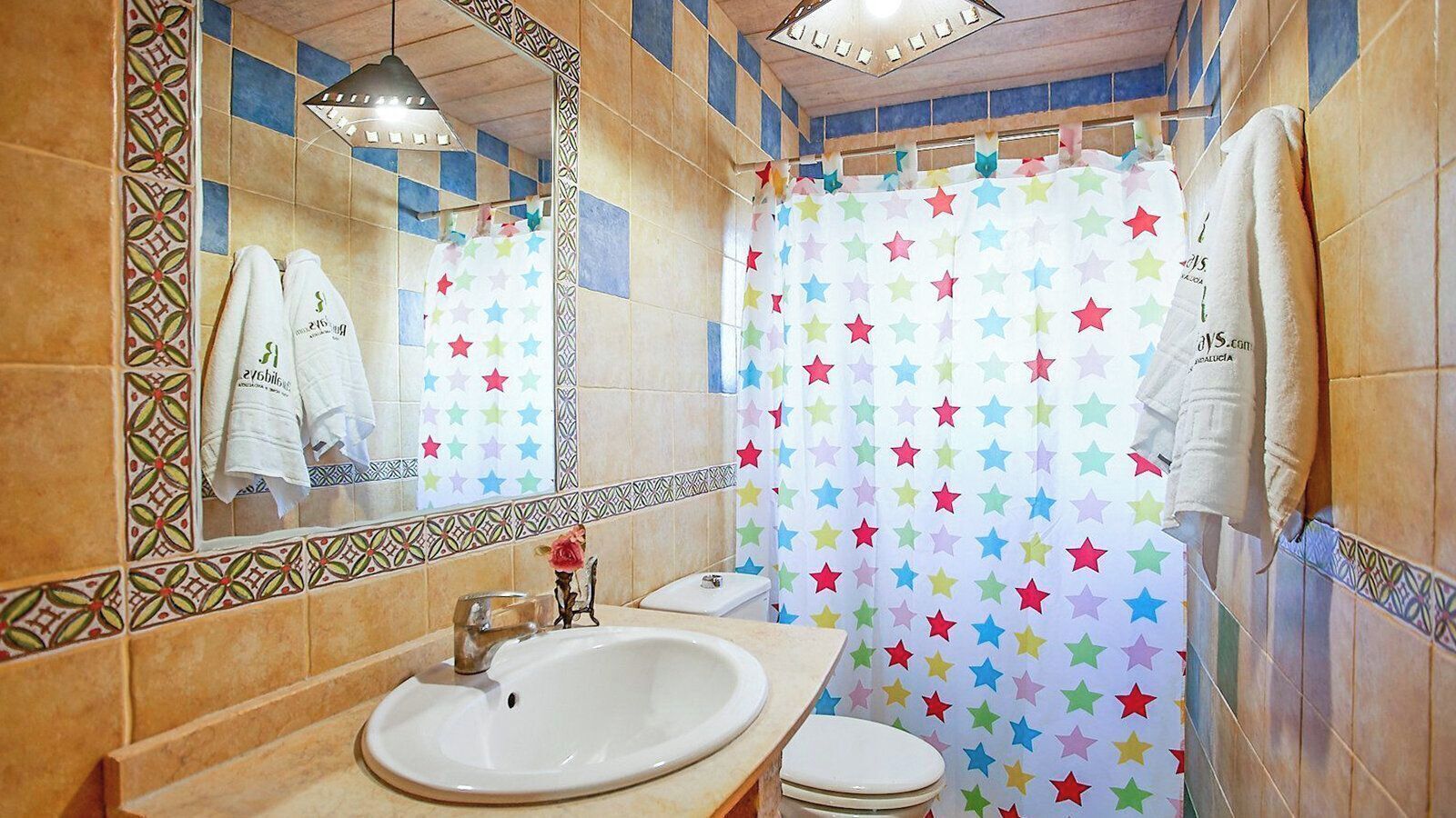 A bathroom with a white sink, a mirror, and a shower curtain with a star pattern.