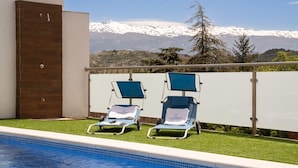 A poolside area with two sun loungers and a view of snow-capped mountains. - Villa Cuesta Colorada Huétor Santillán by Ruralidays (Granada)