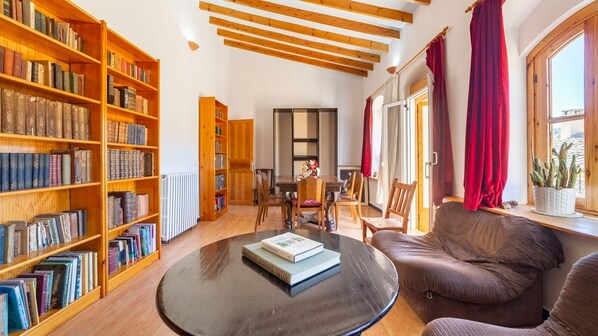A cozy living room with wooden bookshelves, a round coffee table, and a comfortable sofa.