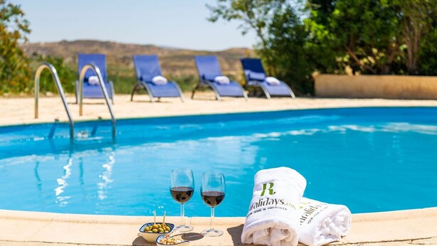 A swimming pool with lounge chairs and a towel with branding.