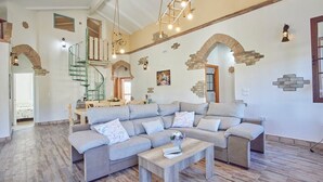 A spacious living room with a large sectional sofa, a wooden coffee table, and a staircase leading to an upper level. - El Rincón de Marco y María Prado del Rey by Ruralidays (Cádiz)