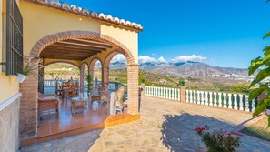 A patio with outdoor furniture, a covered seating area, and a view of mountains. - Villa Jose Miguel Torrox by Ruralidays (Málaga)
