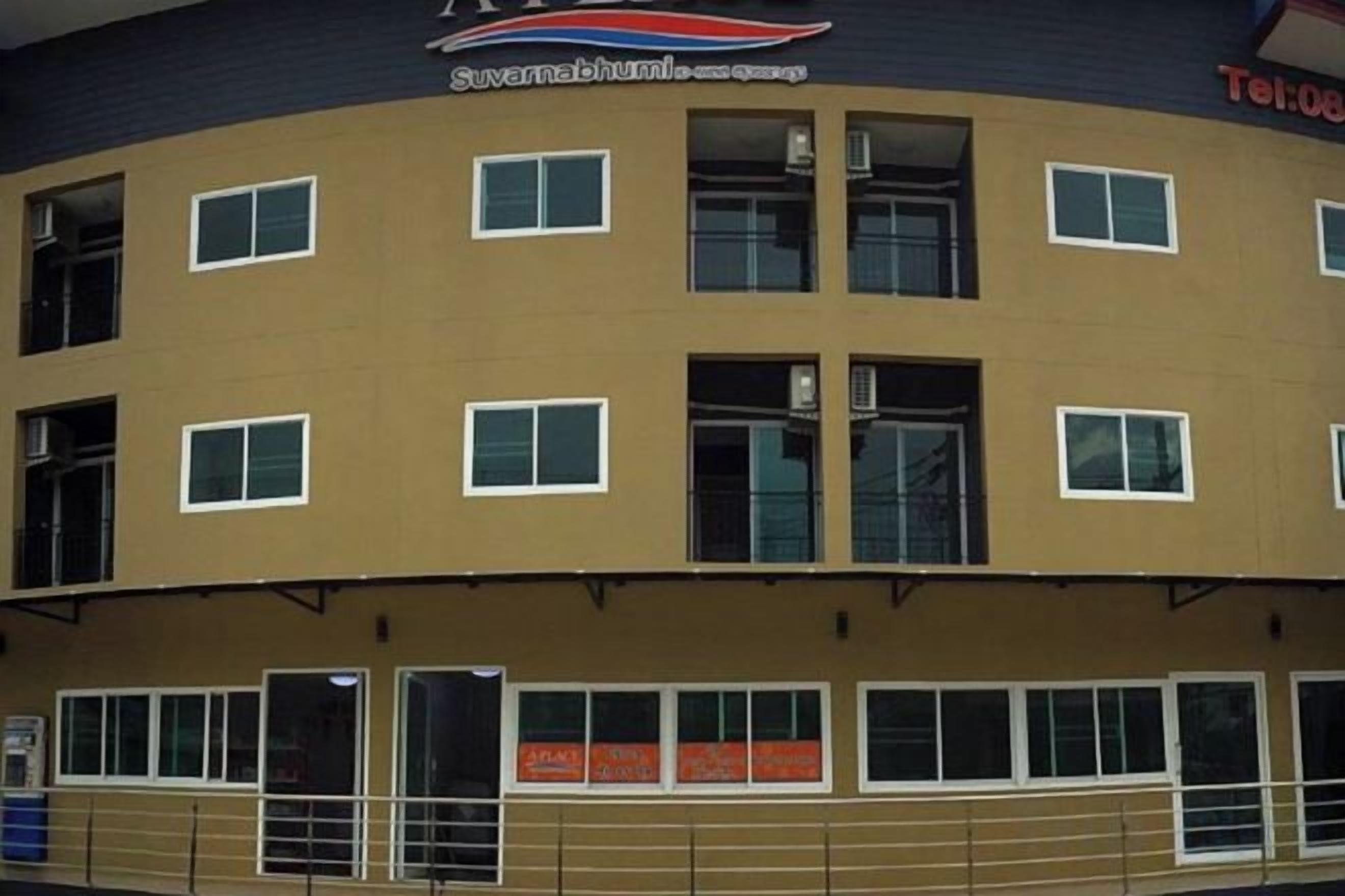Un edificio a più piani con facciata lineare, numerose finestre e un cartello sopra l'ingresso.