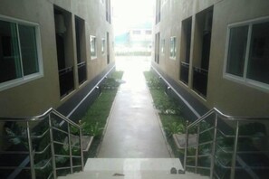A corridor with a central walkway flanked by windows and a metal railing. - A-Place Suvarnabhumi (Bang Phli)