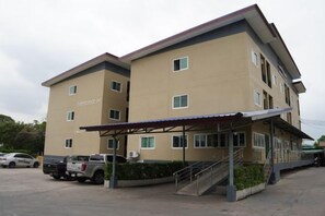 A multi-story hotel with a covered entrance and a parking area. - A-Place Suvarnabhumi (Bang Phli)