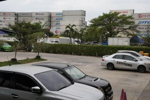 A parking lot with several cars, including a white car with 'SITIHONG' on the side. - A-Place Suvarnabhumi (Bang Phli)