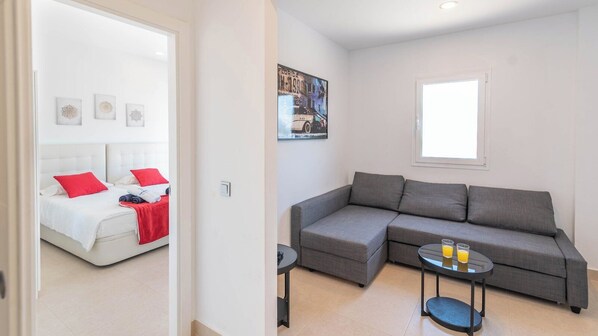 A modern room with a bed, grey sofa, and a small table with glasses of orange juice. - Finca La Mirage Coín by Ruralidays (Málaga)