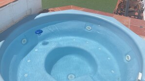 Una vasca idromassaggio con interni blu, un coperchio di scarico e una piccola manopola di controllo.