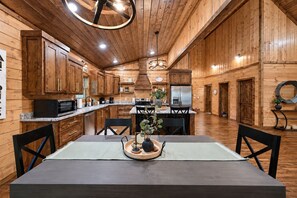 A spacious kitchen with wooden cabinets, a dining table, and modern appliances.