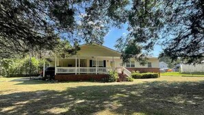 A single-story house with a front porch, a brick foundation, and a small front yard. - Charming 3-bedroom house with AC and WiFi in peaceful Rockingham (Rockingham)