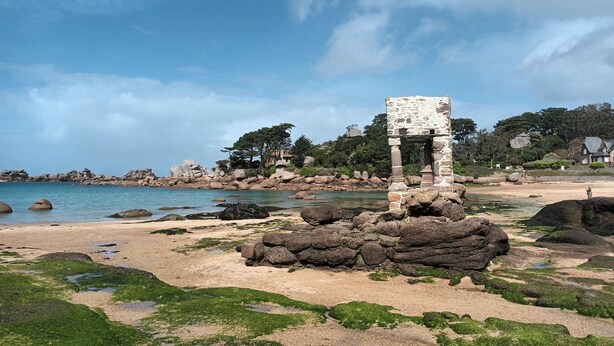 A coastal area with a stone structure on a rocky beach, surrounded by trees and a clear sky. - Le Duplex du Linkin - PERROS GUIREC (PERROS GUIREC)