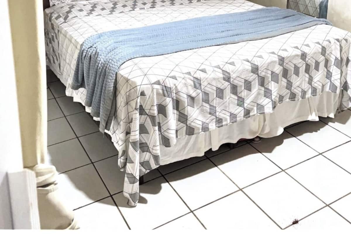 Une chambre à coucher avec un lit, un miroir et un élément décoratif fixé au mur.