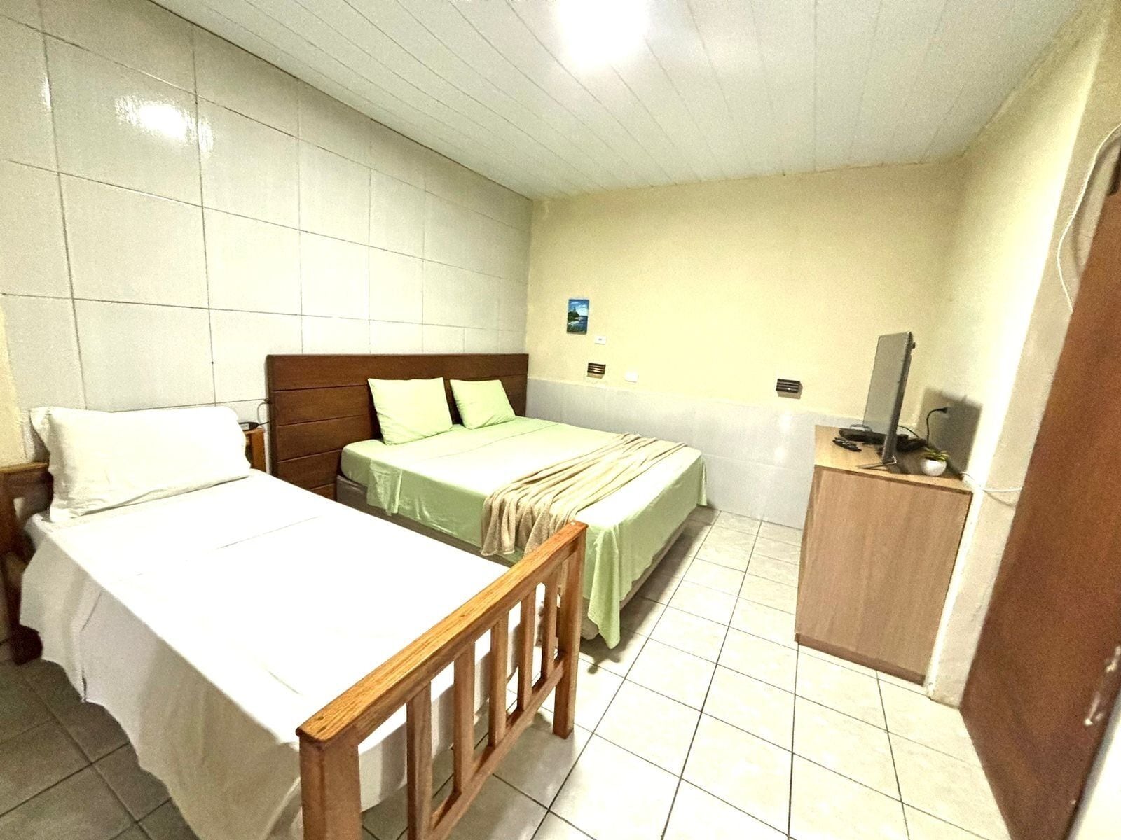 Una habitación de hotel con cama, escritorio y televisor.
