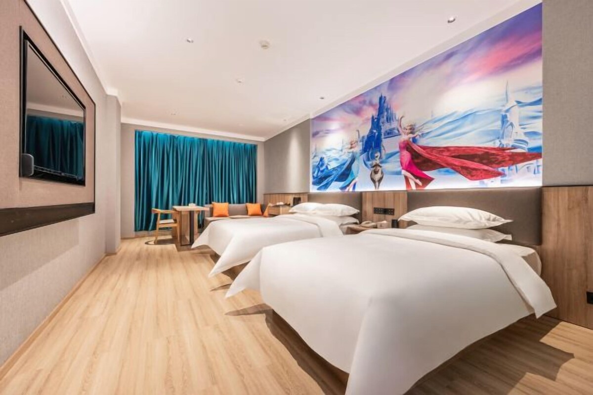 Ein Hotelzimmer mit zwei Betten, einem Schreibtisch und einem großen Gemälde an der Wand.