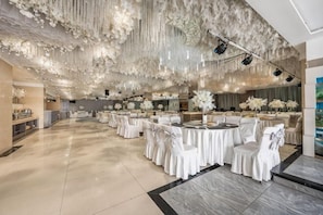 A spacious hall with round tables and white chairs, a high ceiling with hanging decorations, and a marble floor. - Yulin Polentino Hotel (Railway Station Branch) (Yulin)