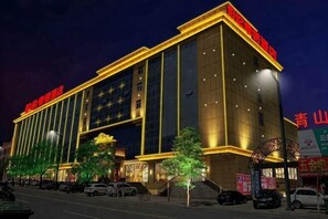 A multi-story hotel with a prominent entrance, large windows, and a well-lit facade. - Yulin Polentino Hotel (Railway Station Branch) (Yulin)