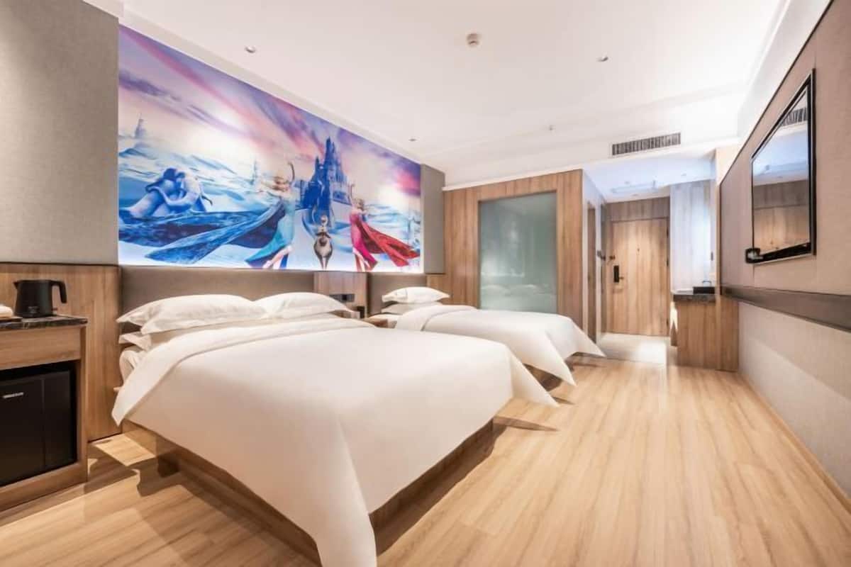 A hotel room with two beds, a large mural, wooden flooring, and a modern design.