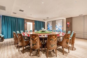 A conference room with a round table, chairs, and a floral centerpiece. - Yulin Polentino Hotel (Railway Station Branch) (Yulin)