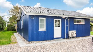 A small, single-story building with a blue exterior, numbered 11, featuring a white door, windows, and a small porch area. - 3 bedroom beautiful home in Thyholm (Thyholm)