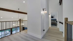 A spacious interior with a high ceiling, wooden beams, and a staircase leading to a lower level. - King David Luxury getaway (Blakeslee)