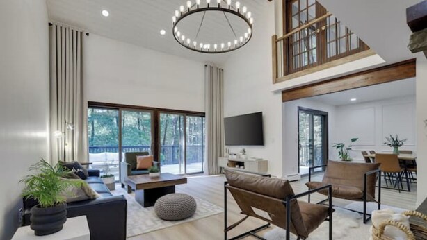 A spacious living room with a large window, a fireplace, and a dining area. - King David Luxury getaway (Blakeslee)