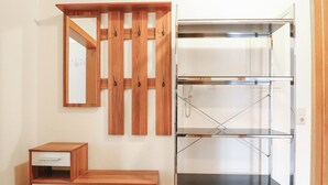 Una habitación con un armario de madera, un espejo y un pequeño mueble de madera.