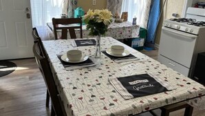 A dining area with a table set for two, a vase with flowers, and a kitchen in the background. - Bright Charming/Netflix/Roku

 (Worcester)