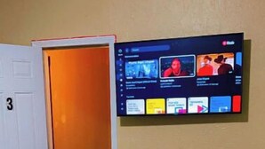 A room with a glass-top table, a door with the number 3, and a wall-mounted TV displaying various channels. - Bright Charming/Netflix/Roku

 (Worcester)