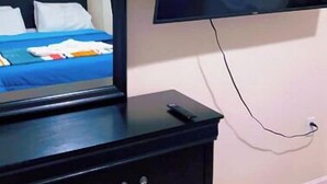 A bedroom with a bed, a dresser, and a TV mounted on the wall. - Bright Charming/Netflix/Roku

 (Worcester)