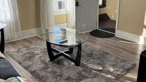 A living room with a glass-top coffee table, a grey rug, and a door marked with the number 3. - Bright Charming/Netflix/Roku

 (Worcester)