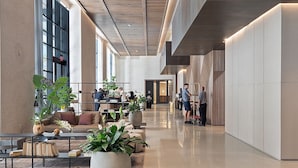 A spacious lobby with a modern design, featuring a long reception desk, comfortable seating areas, and large potted plants. - Luxury 1BD Penthouse • Bay & City Views • Downtown Miami (Miami)