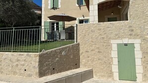 Ein Gebäude aus Stein mit Balkon, einer Tür und einem Fenster.