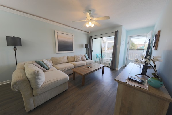 A living room with a sofa, coffee table, and a ceiling fan.