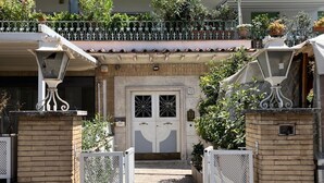 A gated entrance with a decorative metal gate, a tiled roof, and a number '12' sign. - LaDolcevita - Ponte Milvio Stunning View Penthouse (Roma)