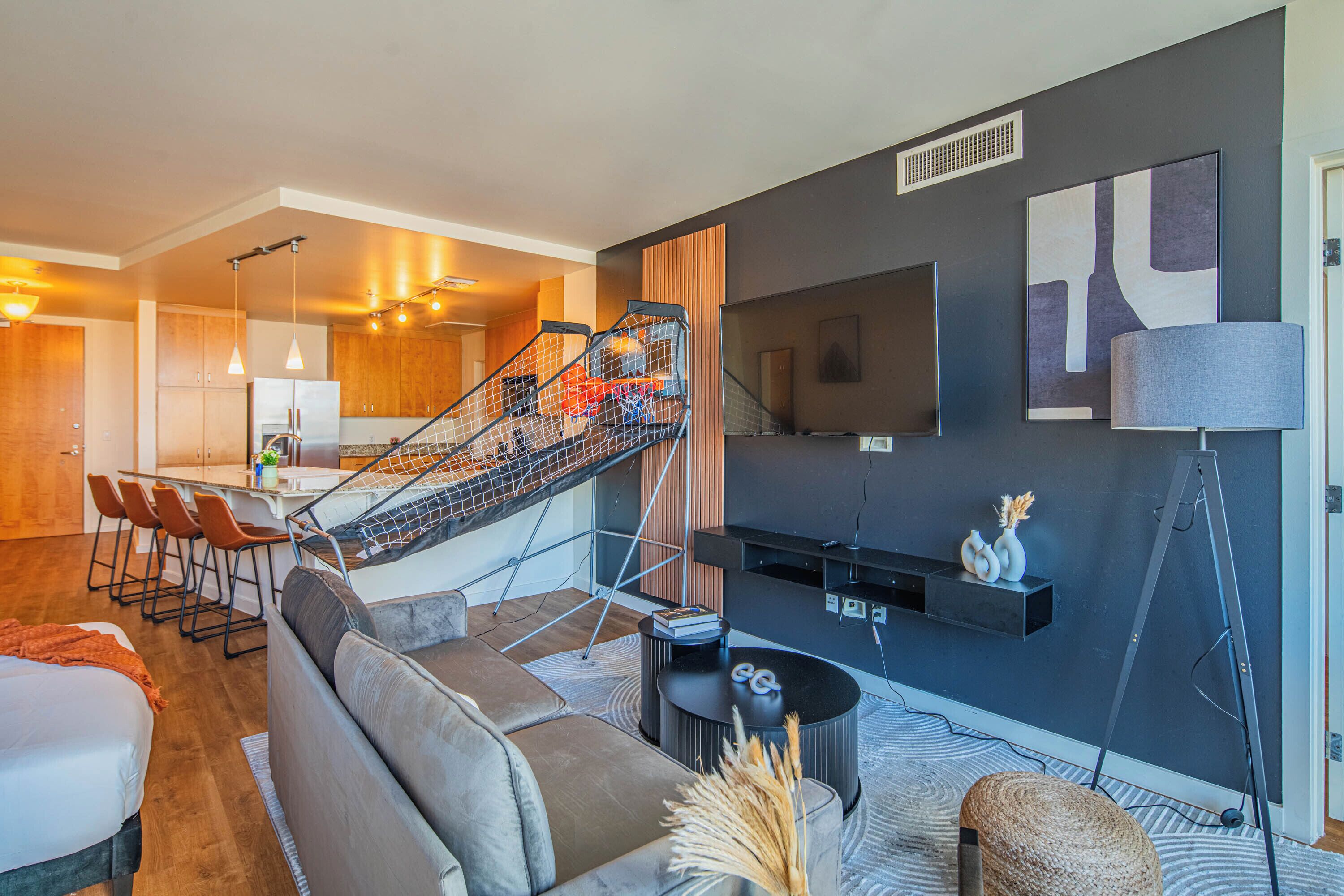 Un salon moderne avec un canapé, une table basse et un escalier menant à un niveau supérieur.
