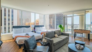 A hotel room with a large bed, a sofa, a coffee table, and a foosball table. - ROVE LIVING/KL - 44 Monroe (Phoenix)