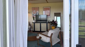 A living room with a television, sofa, and coffee table. - Mountain and Water View at Charming 2-bedroom Retreat in Sequim (Sequim)