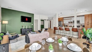 Un appartement moderne comprenant un coin repas, une cuisine et un salon.