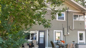 A two-story building with a covered patio area featuring outdoor furniture and a grill. - Cozy 3-bedroom garden level, dog friendly, in the heart of Greeley (Greeley)