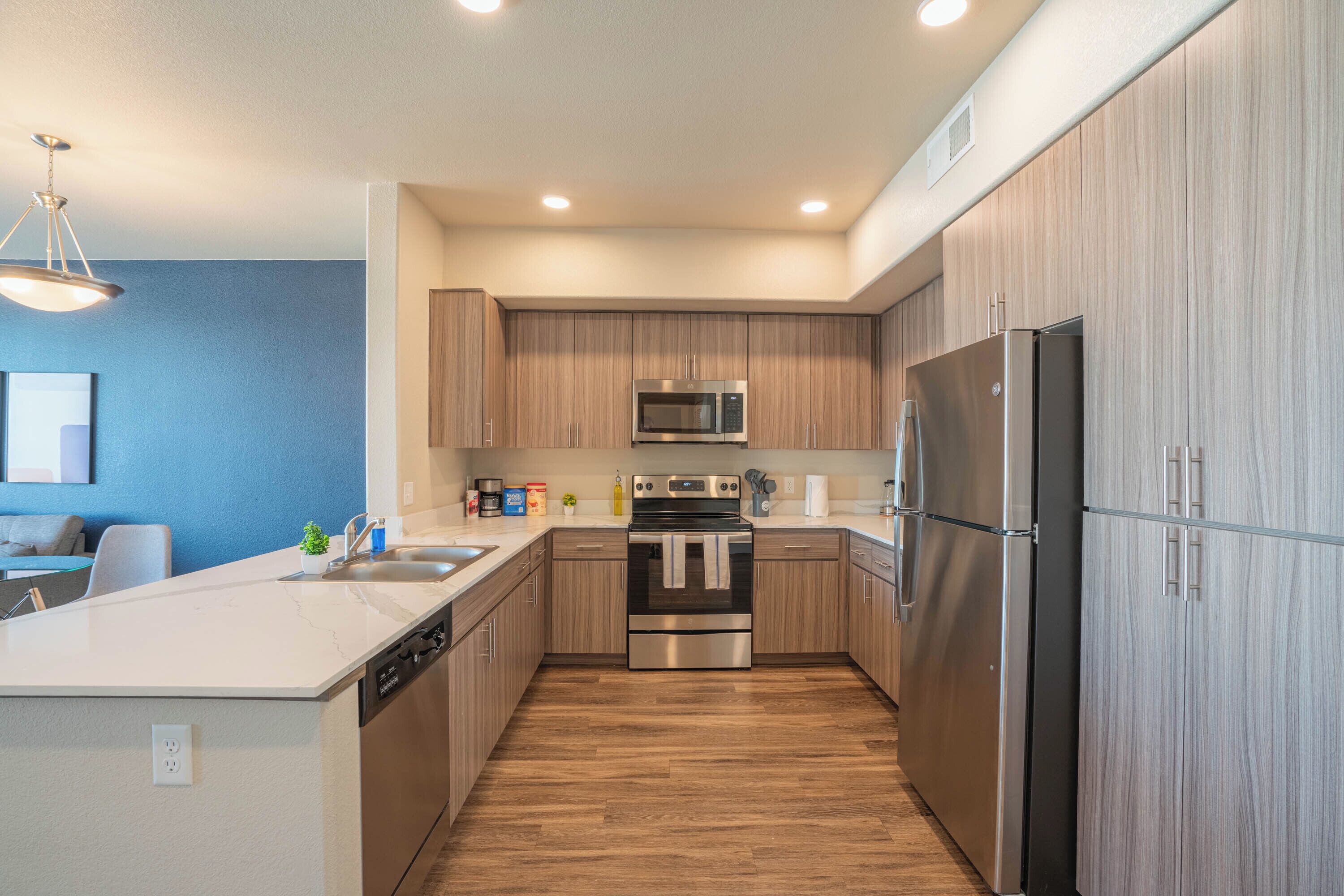 A modern kitchen with wooden cabinets, stainless steel appliances, and a central island.