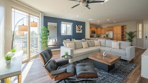 A modern living room with a sofa, chairs, a coffee table, and a ceiling fan. - ROVE LIVING/KL - The Fredrick Tempe (Tempe)